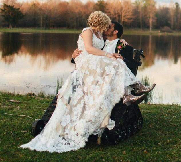 Persona en silla de ruedas todoterreno modelo TR junto a su mujer vestidos de boda
